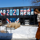 A woman walks past a sign displayed on a building a Drake University that reads “Road To 2020 Starts Here” on February 2, 2020 in Des Moines, Iowa. Tomorrow, Iowa voters will go to their local precincts to caucus for a one of several presidential candidates.